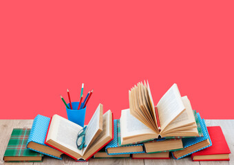 Back to school, pile of books in colorful covers and on wooden table with empty red background. Distance home education.Quarantine concept of stay home.
