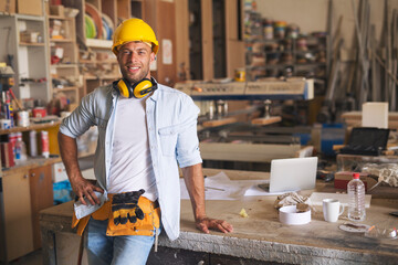 Handsome worker smiling in a carpentry shop