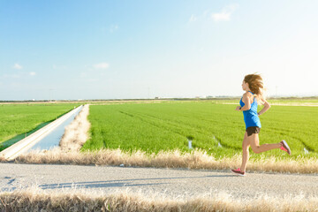 Girl running between rice paddies