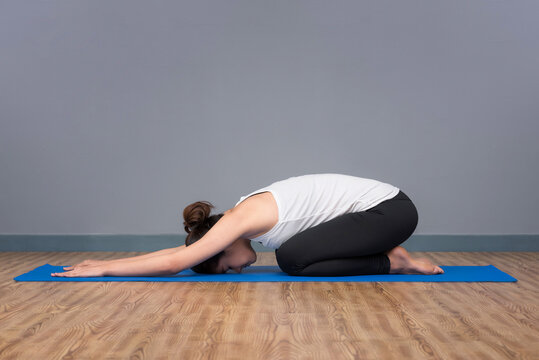 Asian woman practicing yoga pose at yoga healthy sport gym, yoga and meditation have good benefits for health.
