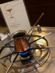 Turkish coffee freshly brewed in a traditional copper cezve