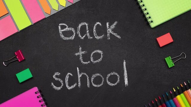 Stop motion of chalk Back to School inscription and various stationery appearing on blackboard