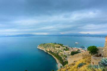 View of the cape, port, the historical part of the city of Nafplion and the island of Bourtzi from the height of the walls of the Themistoklis bastion of Palamidi fortress. Nafplion, Greece