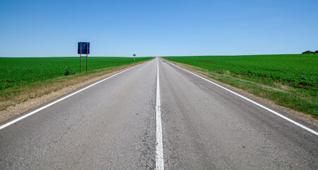 Fototapeta premium an asflatted road leading to the horizon into the distance