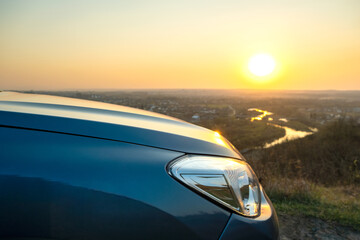 Fototapeta na wymiar Close up detail of front headlight lamp of modern car at sunset.