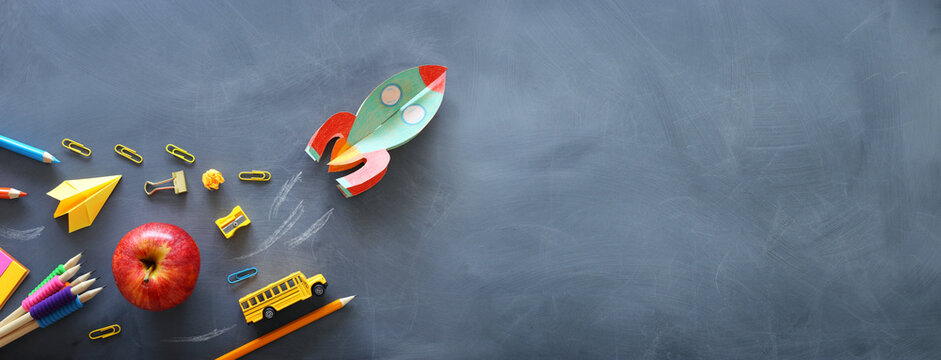education. Back to school concept. rocket cut from paper and painted over blackboard background. top view, flat lay
