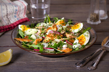 Smocked mackerel fish salad with eggs, arugula and vegetables. horizontal photo