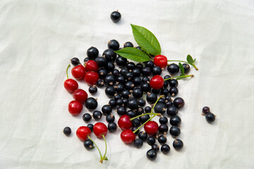Berries of currant and cherry on a light linen tablecloth.