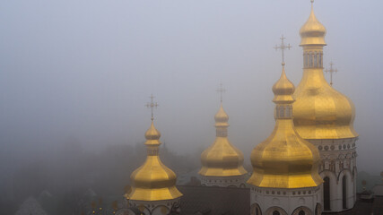 Fototapeta na wymiar Kiev, Ukraine - Foggy view of golden domes in an ancient Ukrainian monastery. Concept photo with a religious theme.