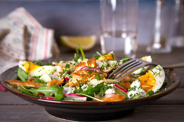 Smocked mackerel fish salad with eggs, arugula and vegetables. horizontal photo