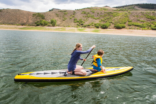 teenage girl and her younger brother on stand up paddle board, Blue Mesa Lake, Crested Butte, CO.