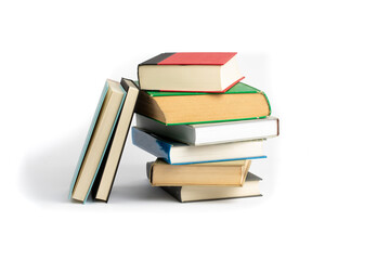 an uneven stack of old hard cover bound books isolated on white