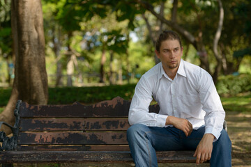 Obraz premium Handsome bearded businessman with long hair at the park