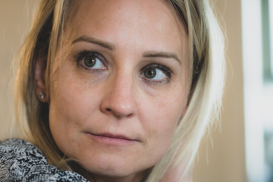 Caucasian woman at a spa with outdoor pool and garden - displaying facial expressions of happiness, anger and sadness. 