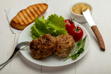 meatballs with tomatoes and lettuce on white background