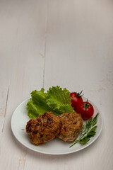 meatballs with tomatoes and lettuce on white background