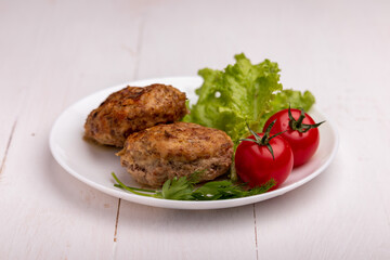 meatballs with tomatoes and lettuce on white background
