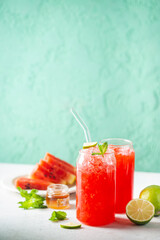 Refreshing cold summer watermelon drink in glasses with slices of watermelon and lime