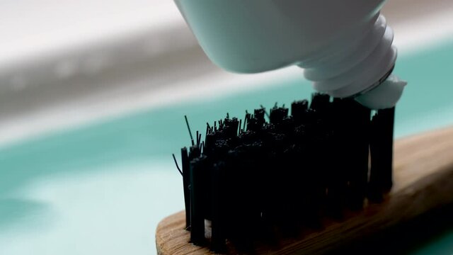 blue toothpaste squeezed onto eco-friendly organic bamboo toothbrush