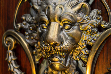 Close up to a golden Iron Lion shiled iluminated with yellow light. Interior design, ornaments and welding concept