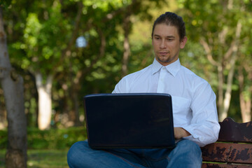 Handsome bearded businessman with long hair at the park