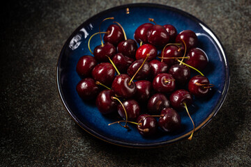 Fresh ripe cherry on blue plate close up