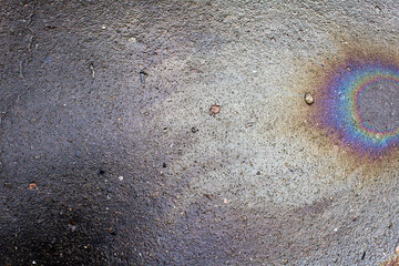 Colorful abstract cosmos comet shape petrol spot on grey city asphalt road 