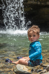 boy playing in the waterfall in el Yunque national park in puerto rico 