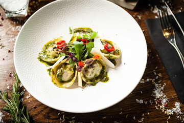 Black Angus hand-made dumplings. Cucumber-julienne with chilli-garlic butter or beef stock with sour cream. Delicious meat food closeup served on a table for lunch in modern cuisine gourmet restaurant