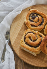 Tasty buns with raisins on a brown rustic wooden table. fresh bakery. breakfast. bread. top view