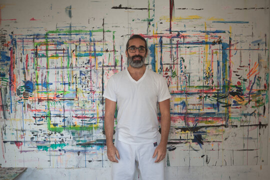 Man dressed in white standing in front of a picture