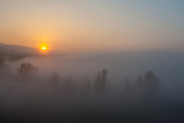Obraz premium Beautiful foggy autumn sunrise landscape.