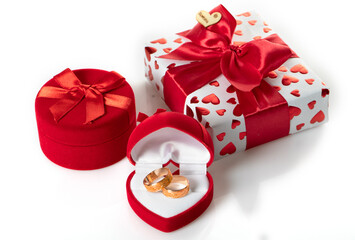 Two wedding rings in a red heart-shaped box