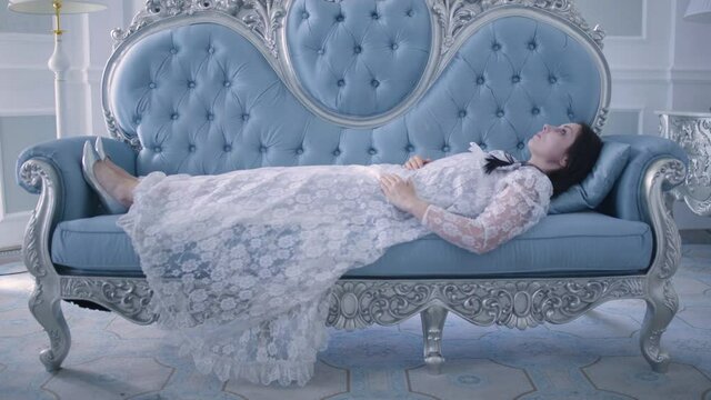 Young princess dying on the sofa, sleeping beauty, fairytale character, lethargy