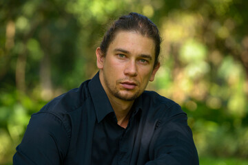 Handsome bearded businessman with long hair at the park