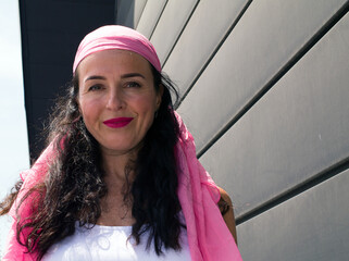 Young girl posing with a pink scarf fighting breast cancer