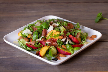 Peach and cured ham salad with cheese, basil, arugula and cucumbers