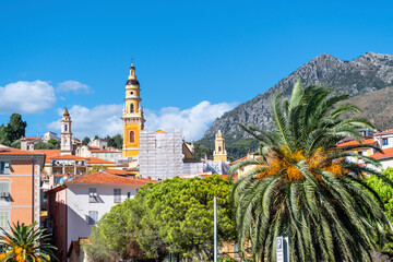 The bell tower of the Basilica of Saint Michel Archange rises above the picturesque village of Menton, France, on a sunny day along the French Riviera