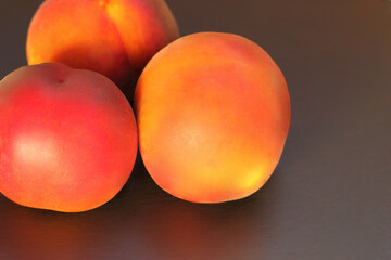 Ripe peach fruit, three  peaches (Prunus persica) close-up on black background