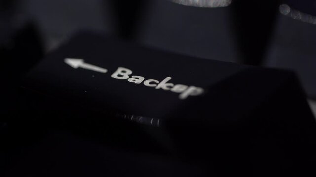 Macro view of Human finger pressing a Backspace key on the computer keyboard