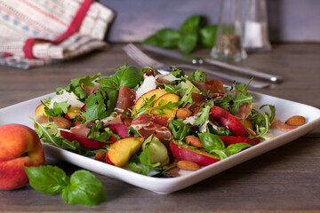 Peach and cured ham salad with cheese, basil, arugula and cucumbers