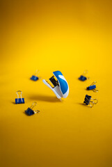 Blue stapler on a yellow background. Office supplies, stationery for school and schoolchildren. Place for your text.