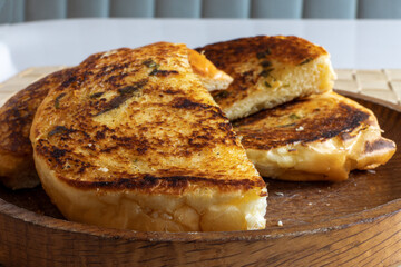 extreme closeup of pieces of fried ortoasted sourdough bread on a wooden plate