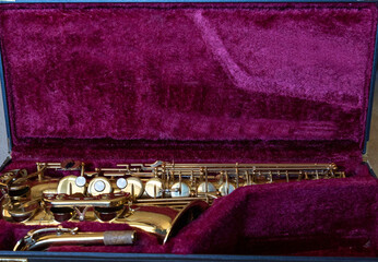 Saxophone laying in a case.  Musical instrument ready to be played at a concert or in a marching band. 