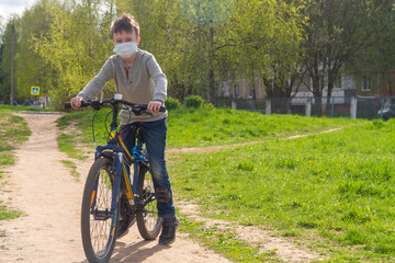 Fototapeta premium Teen boy in medical masks ride bicycles in the playground