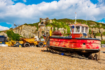Fototapeta premium The view of a fishing vessel and equipment on the beach at Hastings, Sussex, UK in summer