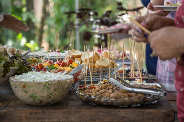 Pessoas se servindo em mesa de buffet.