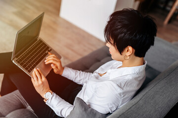 High angle view of a beautiful young business woman using laptop computer on couch at home