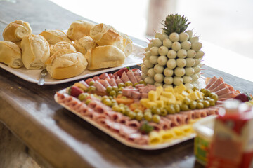 Bandeja com porção de frios e pães.