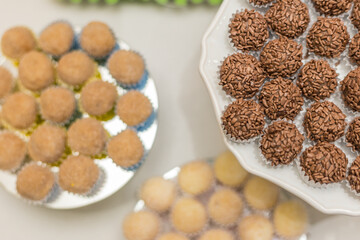 Docinhos arranjados em pratos sobre mesa para festa.